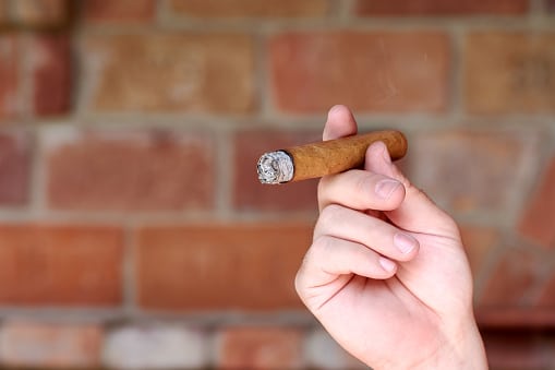 holding a cigar