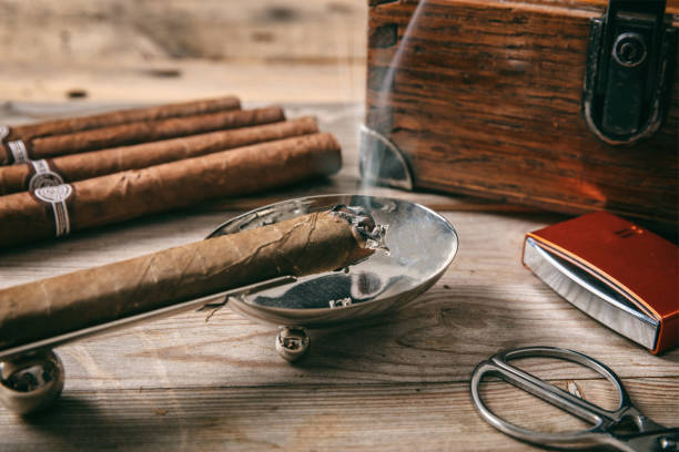 Cuban cigars and smoking accessories on wooden background